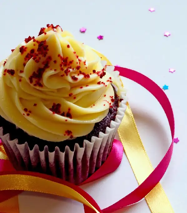 A chocolate cupcake with yellow frosting