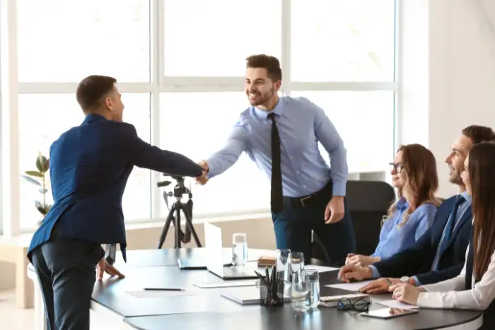 people shake hands after a successful interview for a finance job