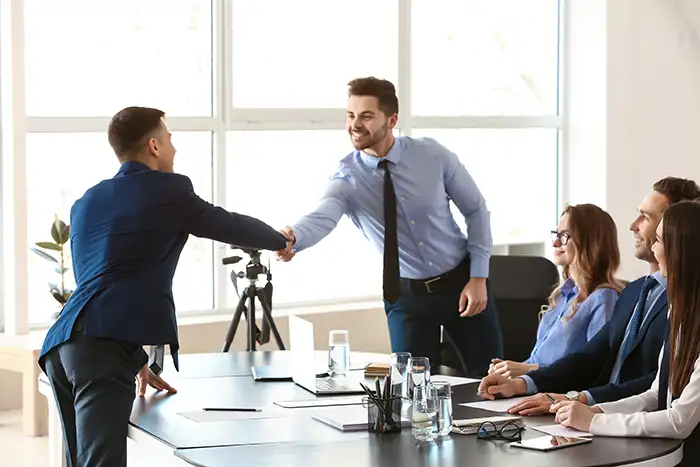 A candidate shakes hands with the interview team after being successfully recruited